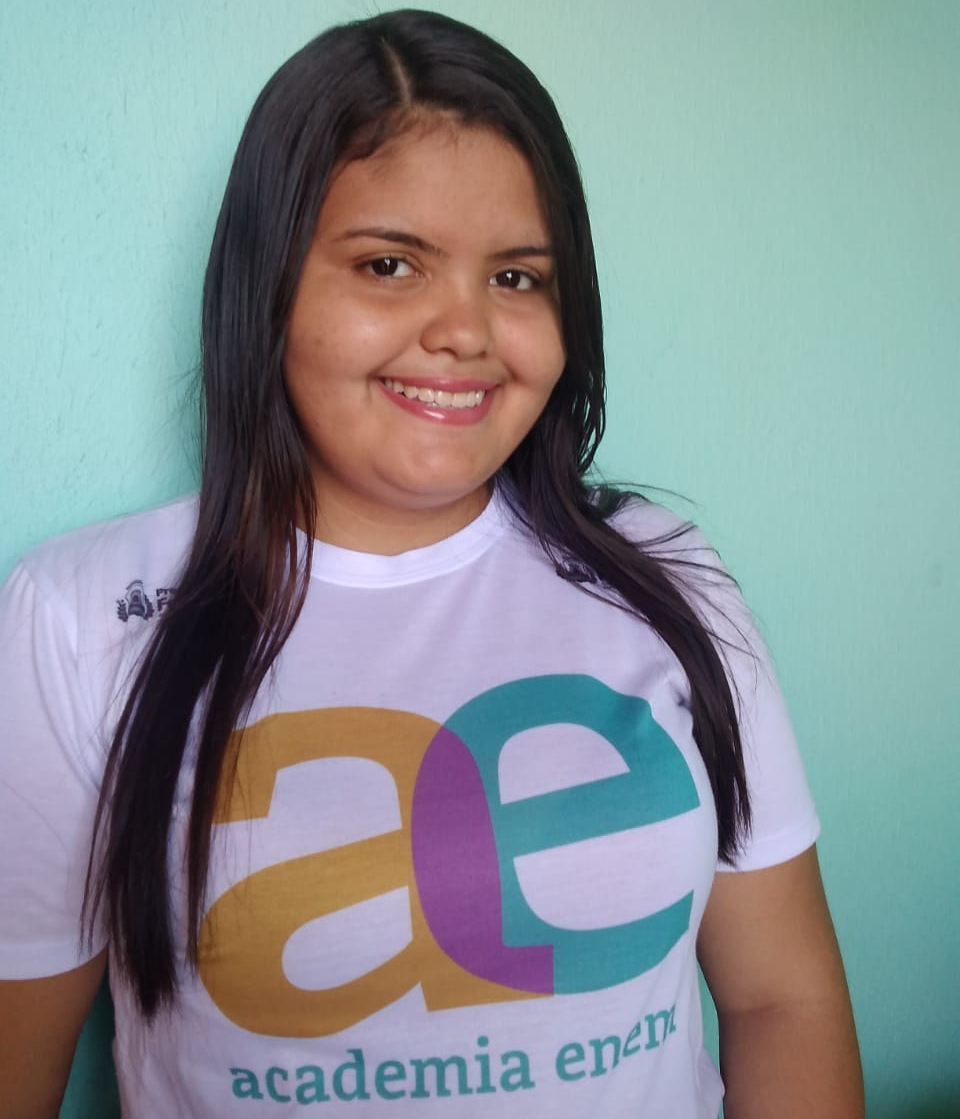 Garota adolescente vestindo camiseta da Academia Enem e sorrindo para a foto